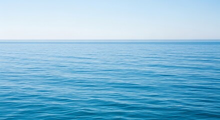 Naklejka premium A serene and tranquil seascape featuring the calm blue ocean surface meeting a clear sky at the distant horizon line