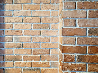 Close up of an old, weathered orange brick wall corner with rough texture and white mortar.