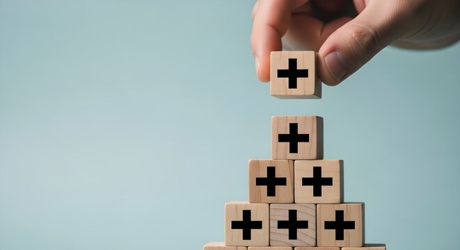 Hand Placing Plus Sign Block on Wooden Pyramid Growth Addition and Expansion Concept