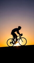 Fototapeta premium Silhouette of a cyclist in motion against a warm sunset sky cycling bike