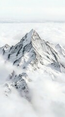 Obraz premium A dramatic, snow-covered mountain peak emerges from a sea of soft, white clouds, highlighting its sharp ridges and icy texture.
