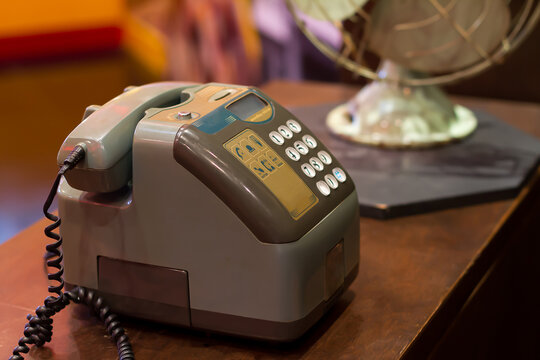 Retro-style landline phone on a wooden table, Old coin-operated public telephone