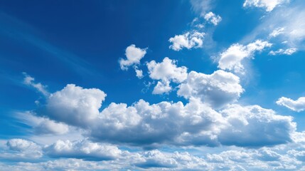 Bright blue sky dominates the scene with large fluffy clouds scattered throughout. Sunlight shines on the clouds creating a peaceful atmosphere in the daytime.