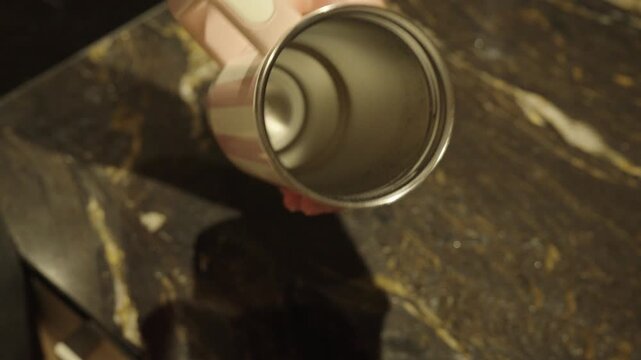 A person cleans a thermos bottle, highlighting hygiene, bacteria prevention, and the importance of regular cleaning for health and safety.