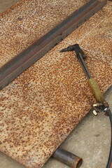 Metal cutting torch on rusty metal sheet with steel beam