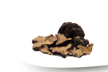 Cut and whole black truffles isolated on white