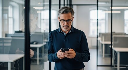 Focused Businessman Wearing Glasses Texting on Smartphone in Modern Office Environment