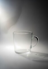 Minimalist transparent mug standing in a clean elegant setting, still life
