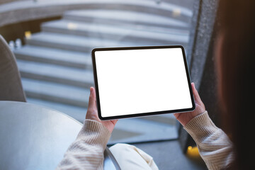 Mockup image of a woman holding digital tablet with blank white desktop screen in cafe