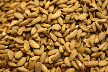 Raw almond nuts texture background showing whole shelled almonds pile and natural brown skin
