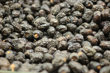 Dried black persimmon fruit texture background showing dark preserved fruit natural closeup pattern