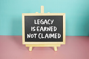 Legacy Is Earned Not Claimed text on easel blackboard