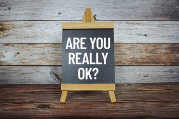 Are You Really Ok? text on easel blackboard on wooden background