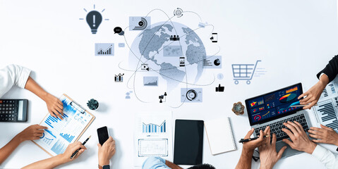 Group of professionals engaged in a business meeting, analyzing charts and graphs while discussing strategies with digital devices in a modern office setting. Trope