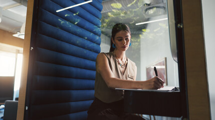 Creative, woman and writing with feedback in booth with notes, brand manager and privacy for...
