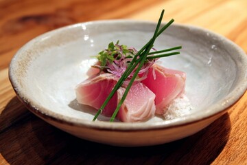Fresh raw tuna sashimi served in a white bowl with garnish