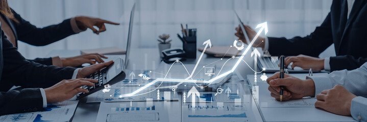 A group of professionals collaborates in a modern office setting, analyzing financial data and discussing strategies for business growth through visual graphs and charts. Trope