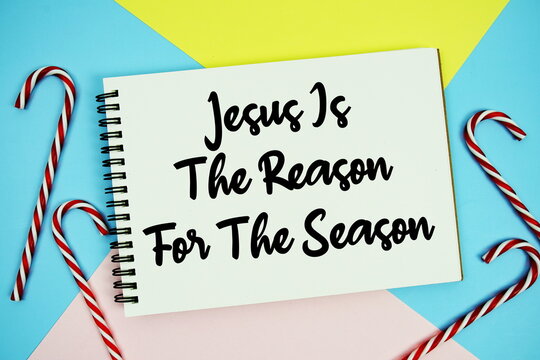 Jesus Is The Reason For The Season message of season holidays written on notepad with candy cane decoration on pastel background