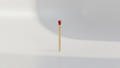 Single matchstick standing upright on a white surface.