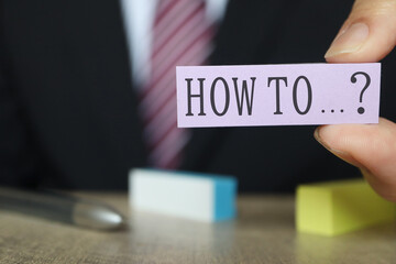HOW TOを示す付箋とビジネスマン。