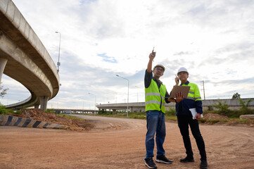 Construction engineers supervise infrastructure work at elevated road construction site. Inspect structure, supervise new road construction, civil engineer working at construction site.