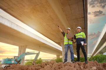 Civil engineers inspect elevated highway structure at infrastructure construction site. Supervise new road construction, structural inspection, construction work in Thailand Asia.