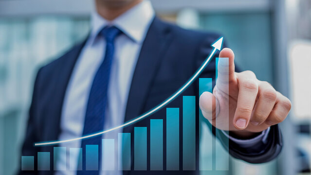 Businessman in a suit pointing to a glowing ascending bar graph, symbolizing financial growth, successful investment, and corporate strategy