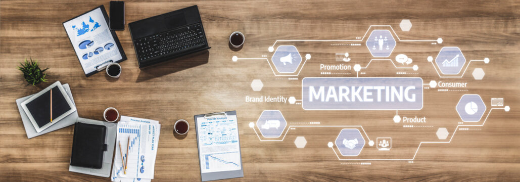 A top-down view of a modern office workspace showcasing business marketing strategy elements, digital icons, documents, coffee, and a laptop, emphasizing promotion and brand identity. Tessel