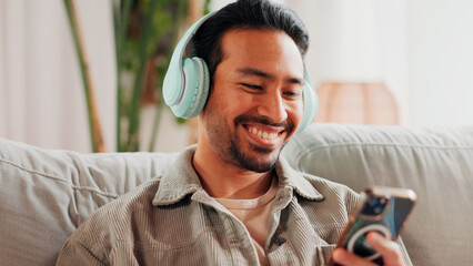 Happy, man or phone with headphones on sofa for streaming music, social media or weekend break....