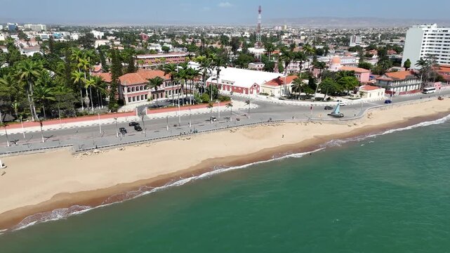 Drone footage of Benguela seafront, Angola, capturing the beachfront promenade, palm trees, and colonial-style houses facing the Atlantic Ocean