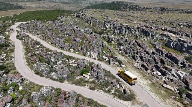 Drone footage of winding mountain road leading to Tundavala Gap, Angola, surrounded by rocky plateau and vast highland landscape in bright daylight