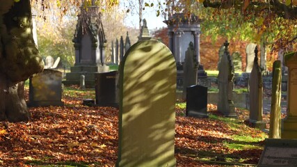 Aged headstones in Autumn in peaceful historic British graveyard