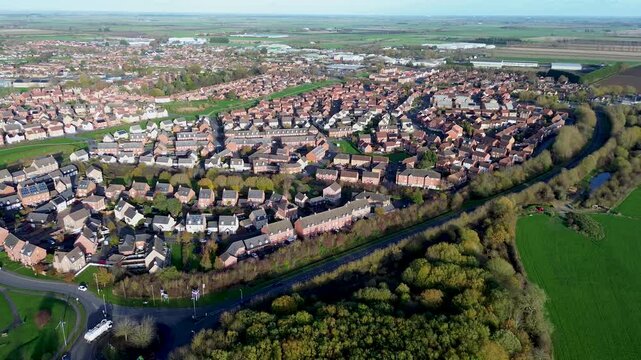 Aerial video of a UK village with patchwork fields and winding country roads