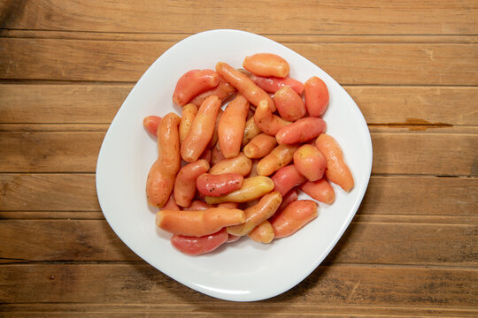 Ulluco tubers on a white plate. Fresh Andean ullucos (olluco), a traditional South American tuber.