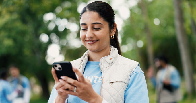Cellphone, woman and volunteer in nature for networking, contact or social media post for outreach. Happy, outdoor and female ngo worker with phone for communication with community service in park.