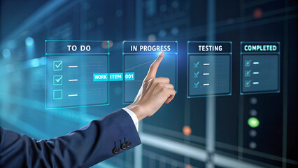Business professional pointing at holographic task board with progress stages in futuristic data center