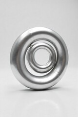 Abstract spiral of polished silver, reflecting light with a metallic sheen, smooth curves, modern elegance, studio shot. An abstract, highly polished silver spiral sculpture with intricate reflective