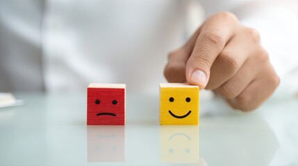 Hand chooses happy block over sad on desk