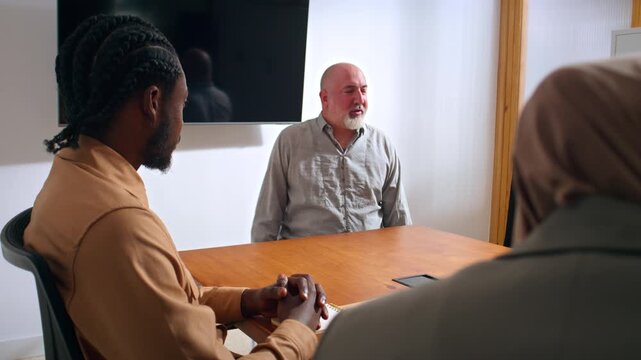 Inclusive and diverse work office. disabled leader in a wheelchair speaking to his work team - Powered by Adobe