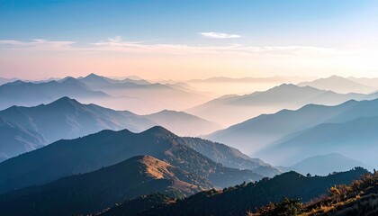 A breathtaking vista of multiple mountain ranges receding into the distance, bathed in the soft light of sunrise and veiled in gentle fog.