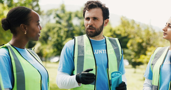 Volunteers, recycling and discussion for project, outdoor and team with trash bag or waste disposal. Forest, clean up and people with social responsibility, talking and community service in woods - Powered by Adobe