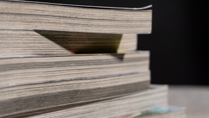 Stacked paperback books in sharp side detail, showing dense page lines and natural wear, ideal for concepts of education, knowledge, vintage reading, or research material.