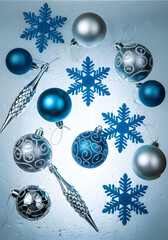 A creative flat lay of Christmas ornaments in various shades of blue and silver, including matte and shiny spheres, textured ornaments, and glittery snowflake cutouts.