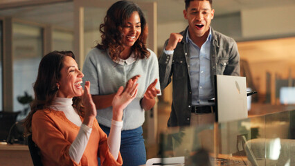 Applause, computer and fist pump with business people in office at night for bonus or victory....