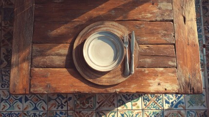 Plate with silverware on rustic wood table over tiled floor