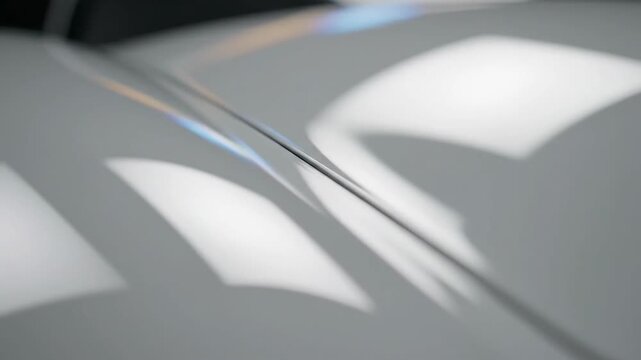 Close-up of a shiny car surface with light reflections.