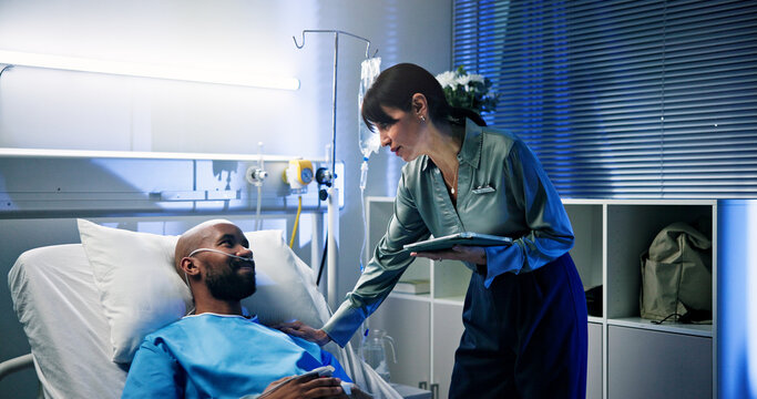 Healthcare, tablet and doctor with man in hospital for surgery recovery, healing or advice. Medical feedback, digital technology and surgeon with male patient for consultation with support in clinic. - Powered by Adobe