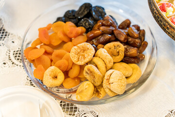Dried fruits served on a decorative plate at a festive gathering in a bright setting
