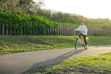 Fototapeta premium Woman enjoying cycling on sunny day in park