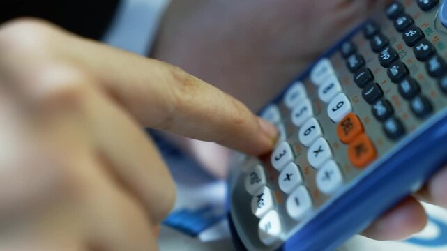 Close-up of a person using a calculator with a blue casing